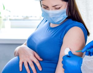 Eine schwangere Frau erhält eine Impfung.
