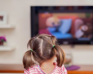 Ein Kind sitzt vor dem Fernseher.